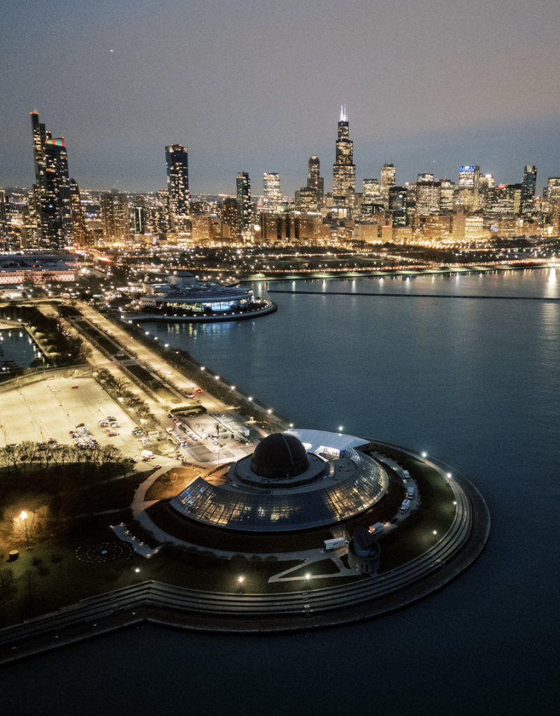 Aerial view of Adler Planetarium with the Chicago skyline at night